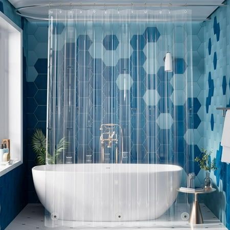 a white bath tub sitting next to a window in a blue and white tiled bathroom