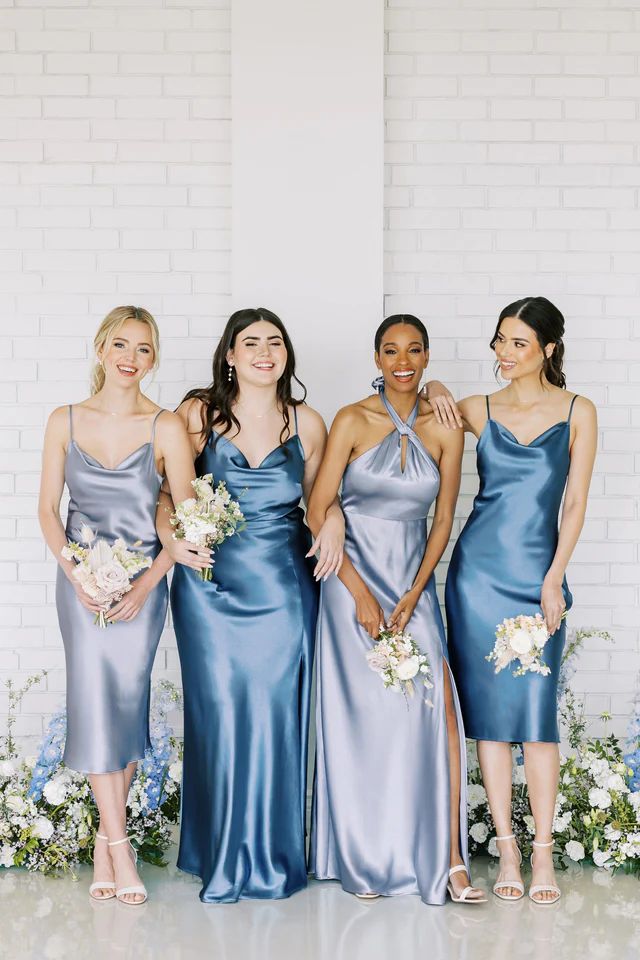 four bridesmaids in blue dresses posing for the camera