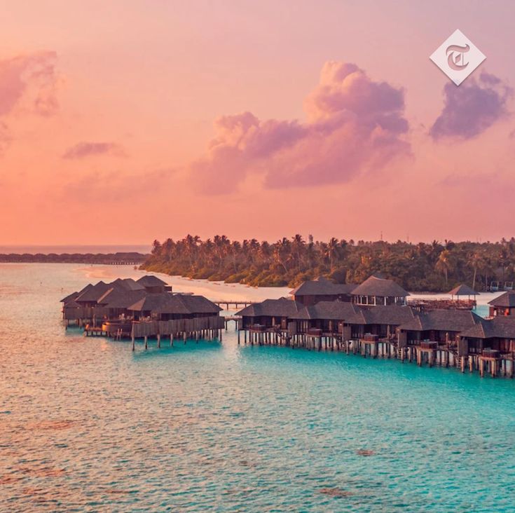 the water is crystal blue and there are overhanging huts on stilfets