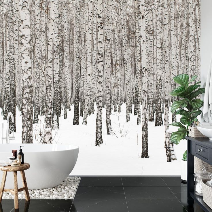 a bath room with a tub and a wallpaper that looks like birch trees in the snow