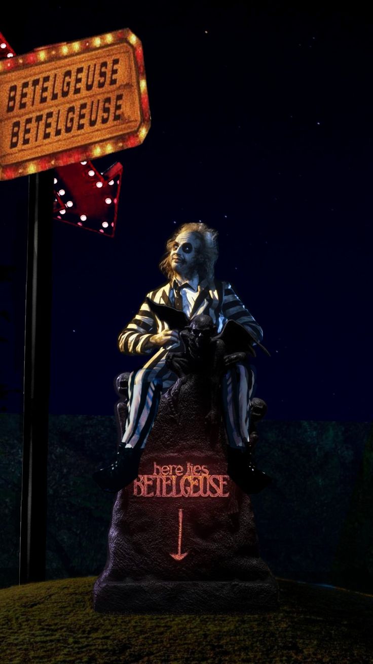 a creepy clown sitting on top of a sign in front of a dark night sky