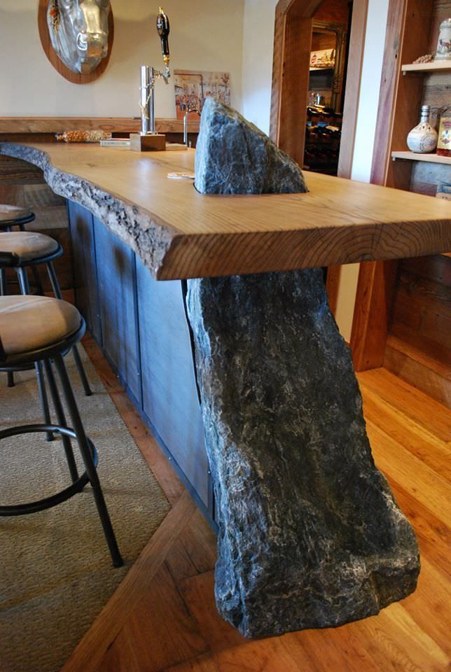 a large rock sitting on top of a wooden counter in a kitchen next to bar stools