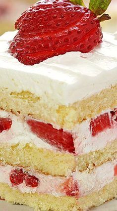 a close up of a cake with strawberries on the top and white frosting