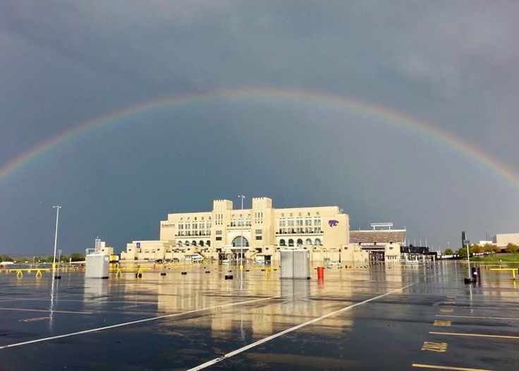 a double rainbow over a parking lot with buildings in the background