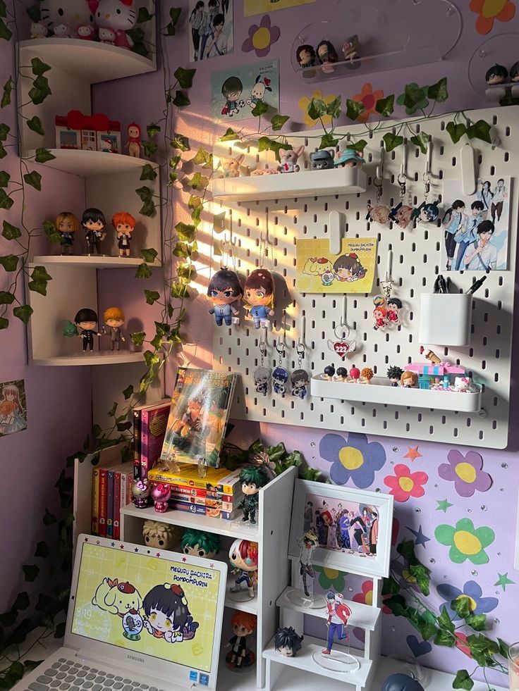 a laptop computer sitting on top of a desk next to a shelf filled with toys