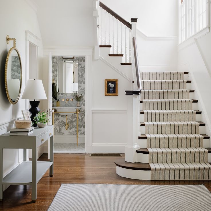 the stairs in this house have been painted white and are lined with striped rugs