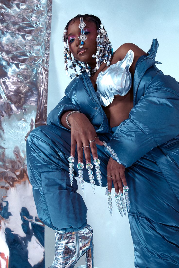 a woman in a blue outfit sitting on a stool