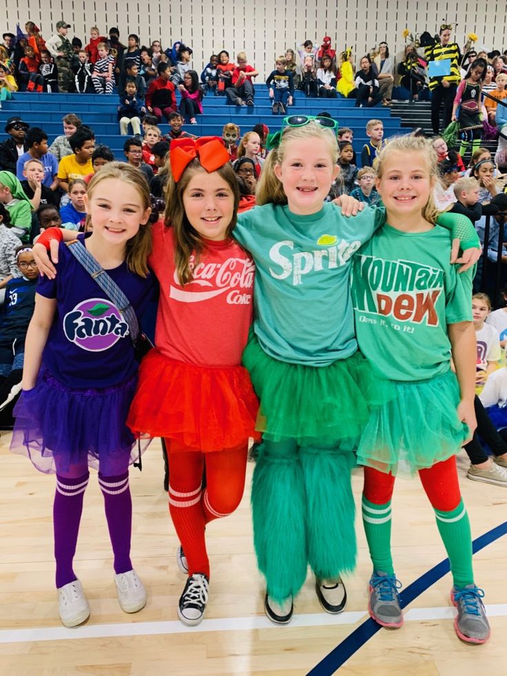 three girls in costumes standing on a basketball court