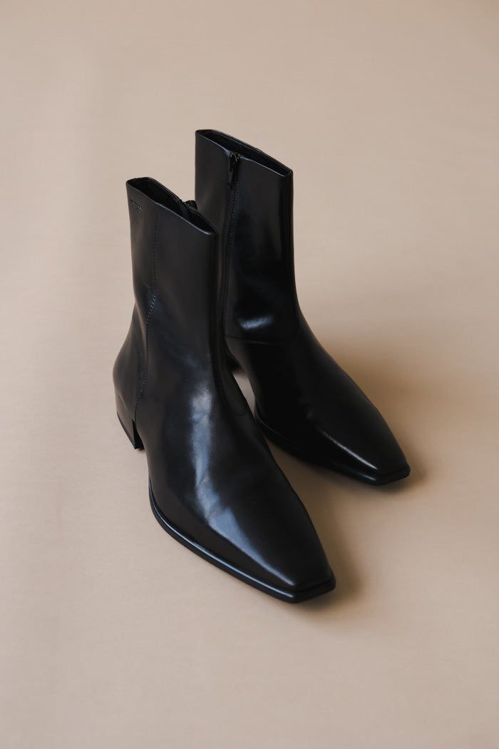 Vagabond elongated toe Nella boots in smooth black leather. The nella are a dressy ankle boots with a contemporary look, featuring a slender toe shape and zipper along the shaft. Measurements from a 37: heel 31mm, shaft height 178mm, shaft width 255mm. Leather upper, tpu outsole, tencel and cotton lining, goat leather inner sole. This style is made by THUONG THANG JSC HO CHI MINH CITY, VIETNAM. 5416-001-20 PIPE AND ROW Point Toe Chelsea Boots, Luxury Plain Toe Chelsea Boots, Low Heel Boots Black, Luxury Medium Width Pointed Toe Chelsea Boots, Dress Boots Black Ankle, Luxury Modern Leather Chelsea Boots, Luxury Sleek Chelsea Boots For Workwear, Sling Back Ankle Boots, Luxury Low-top Classic Boots