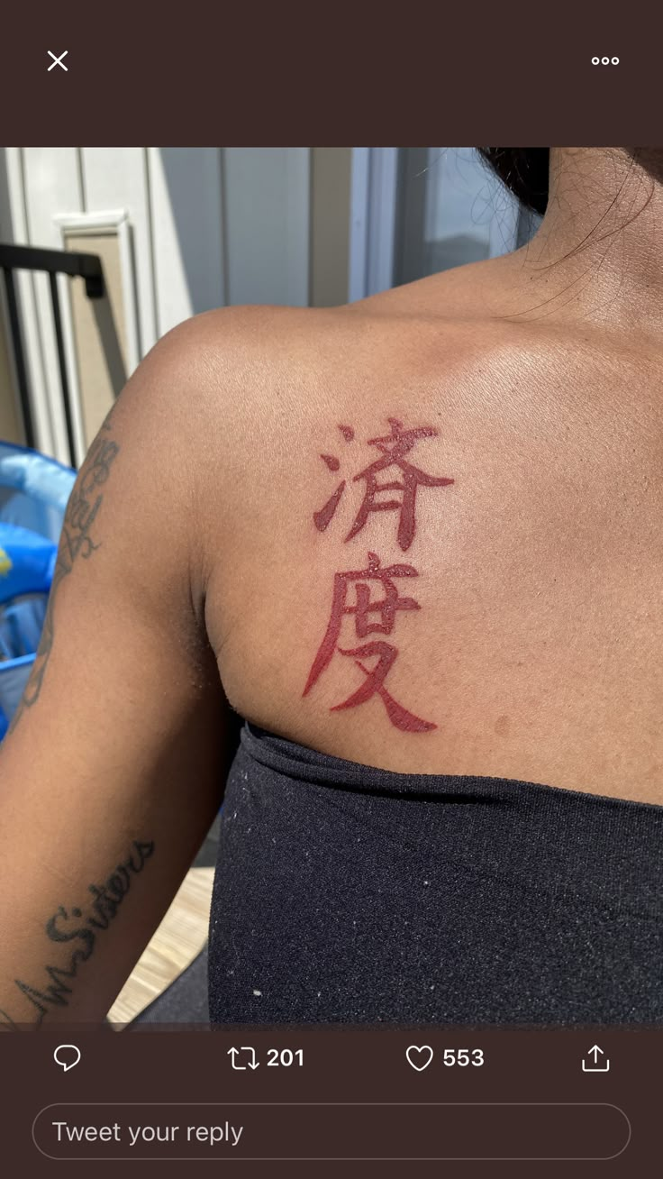 the back of a woman's shoulder with chinese writing on it