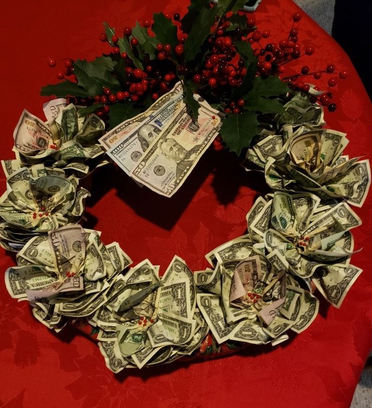 a wreath made out of money sitting on top of a red table