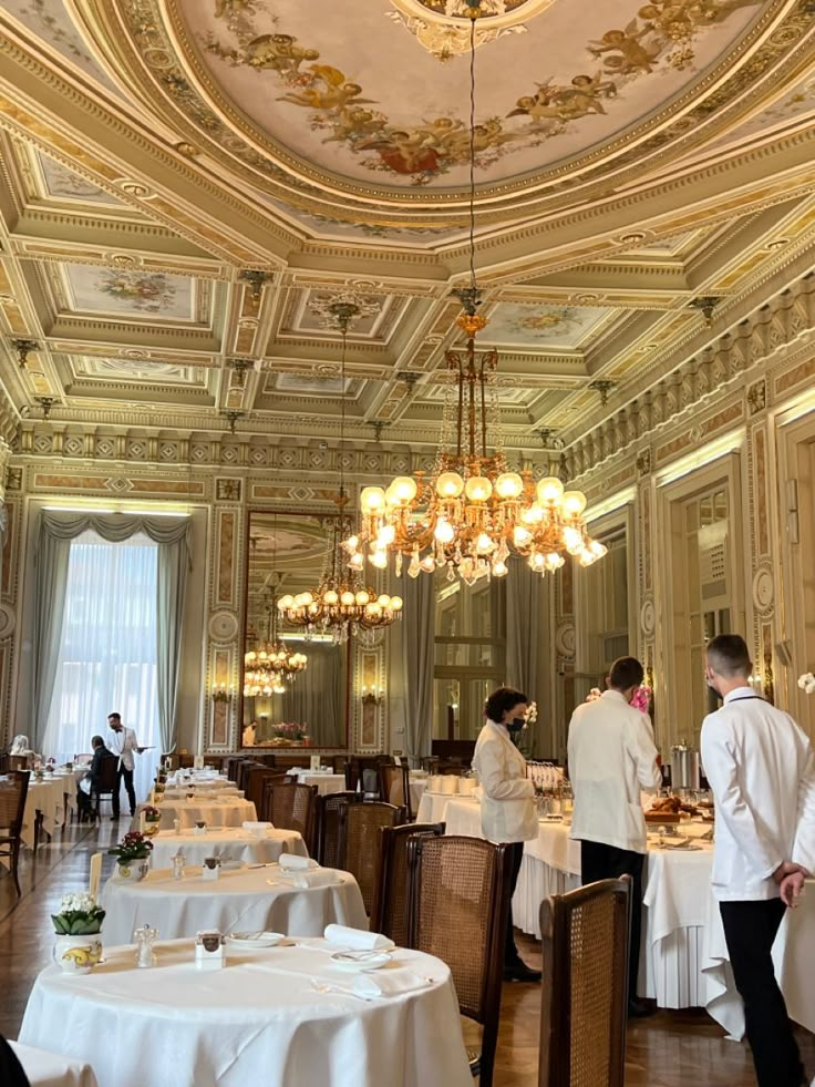 people are standing in the dining room at a fancy restaurant