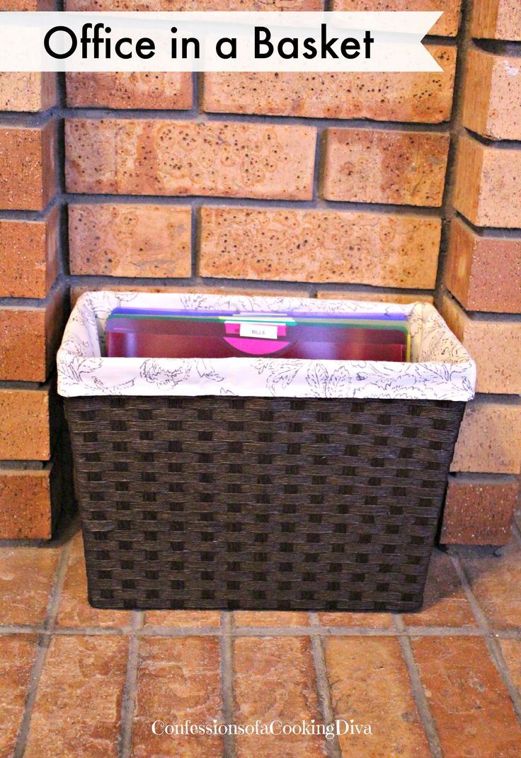 a basket sitting in front of a brick wall with the words office in a basket above it