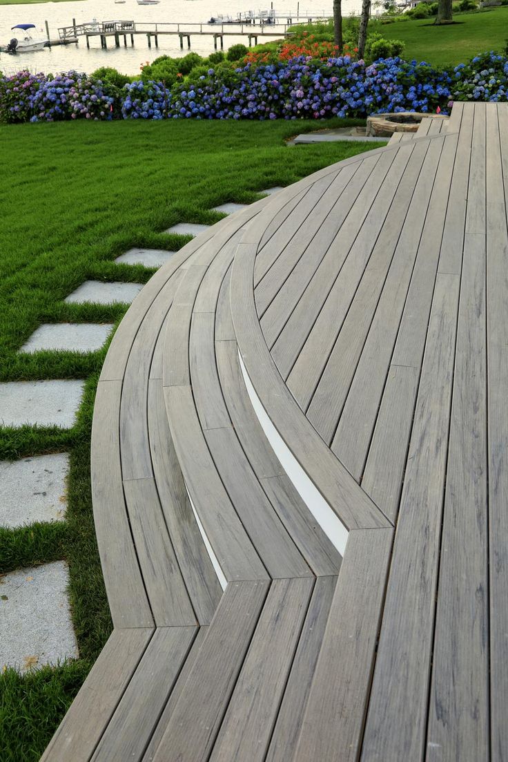 a wooden walkway in the middle of a grassy area