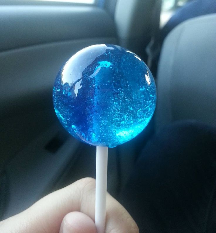 a person holding a blue lollipop in their hand