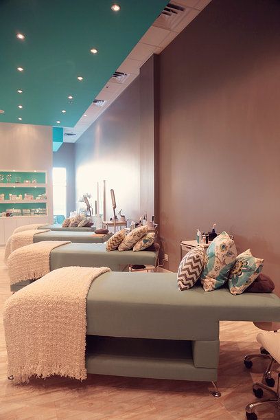 a row of benches sitting in front of a wall filled with pillows and blankets on top of them