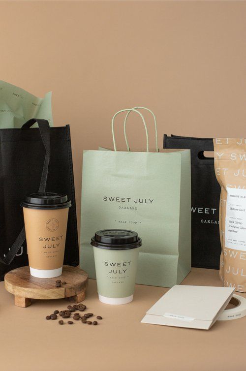 there are coffee cups and bags on the table next to some other items, including a paper bag