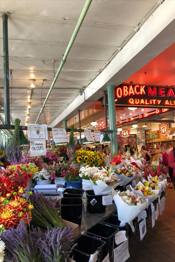 an outdoor market with lots of fresh flowers