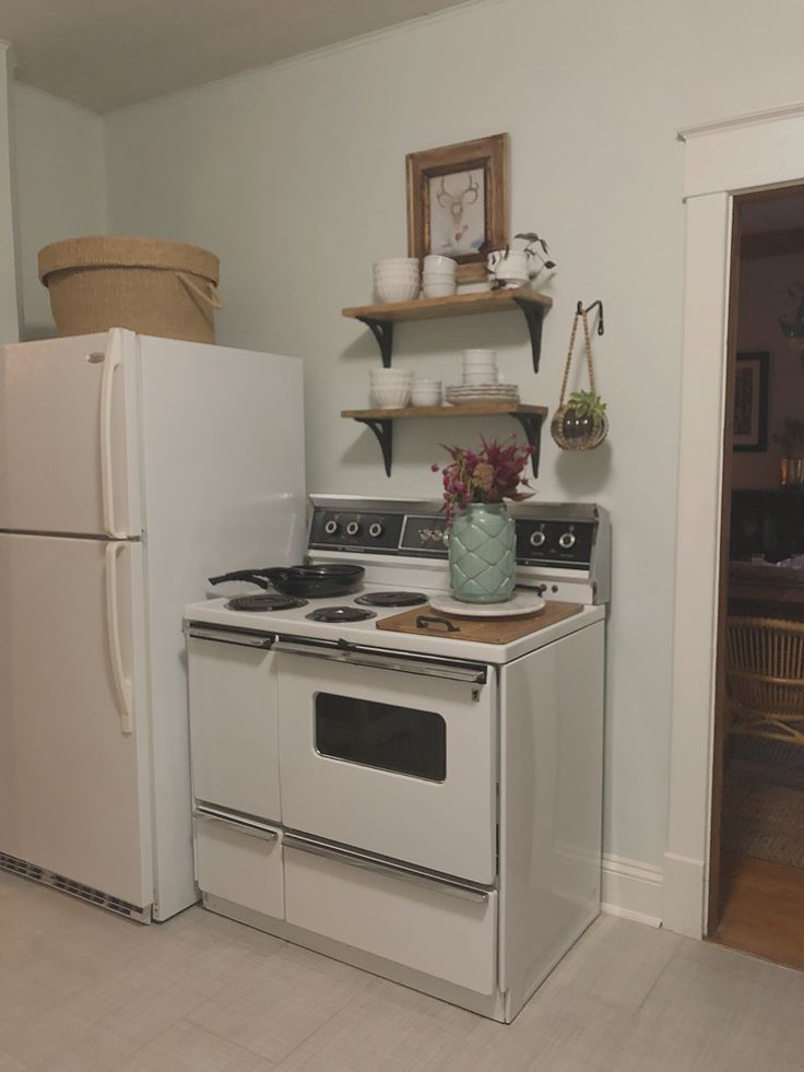 a white stove top oven sitting inside of a kitchen next to a refrigerator freezer