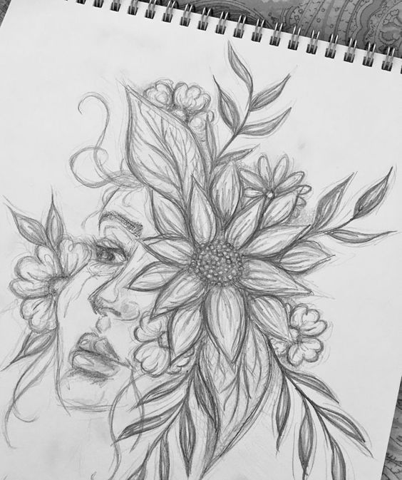 a drawing of a woman's face with flowers in her hair on top of a table