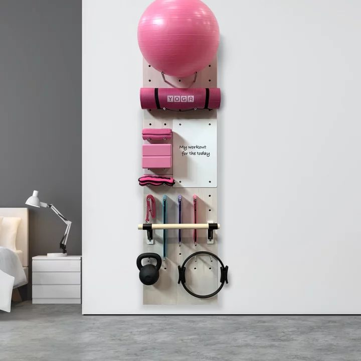 there is a pink ball hanging on the wall next to some exercise equipment in this room