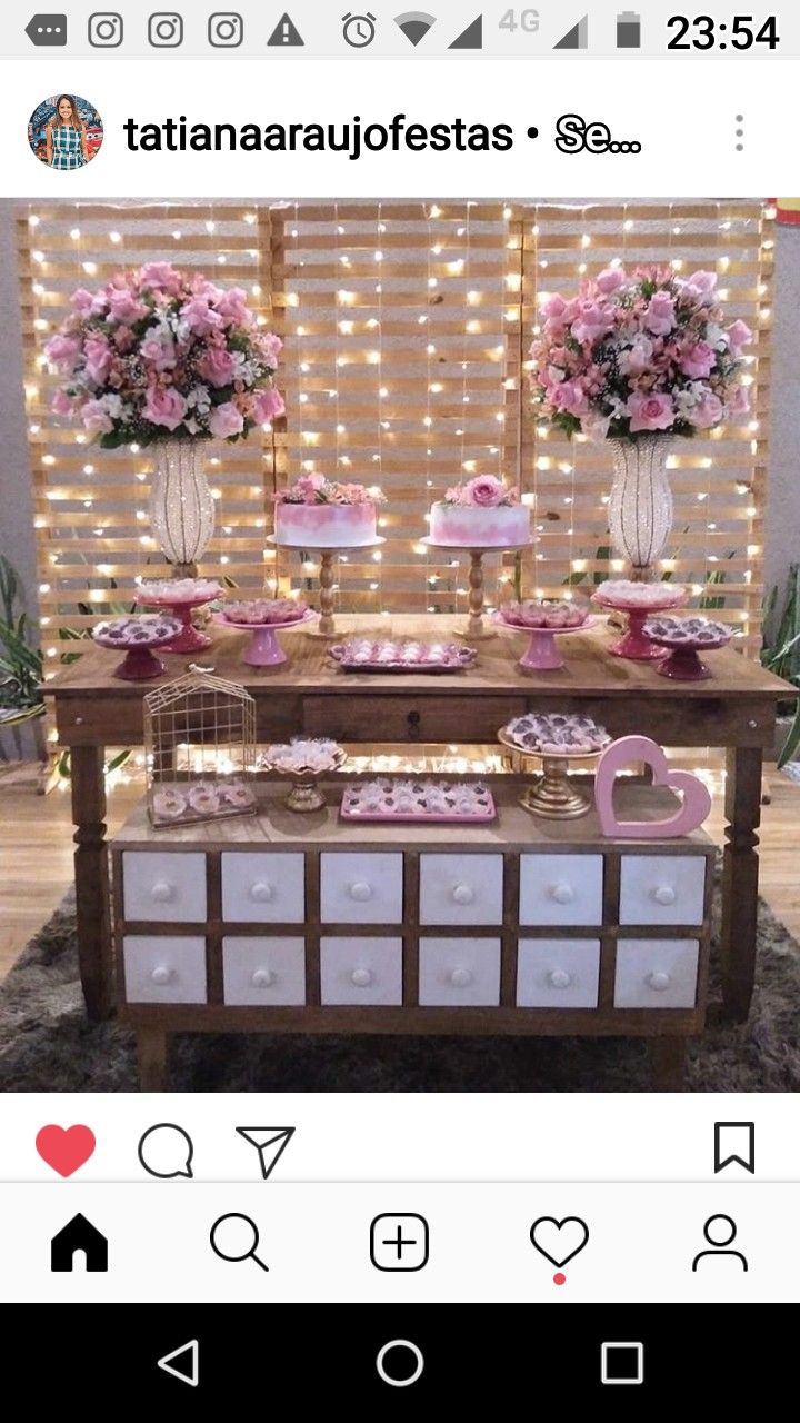 the dessert table is decorated with pink flowers and cupcakes on it's side