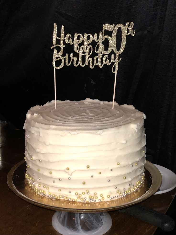 a birthday cake with white frosting and gold sparkles on top that says happy 50th