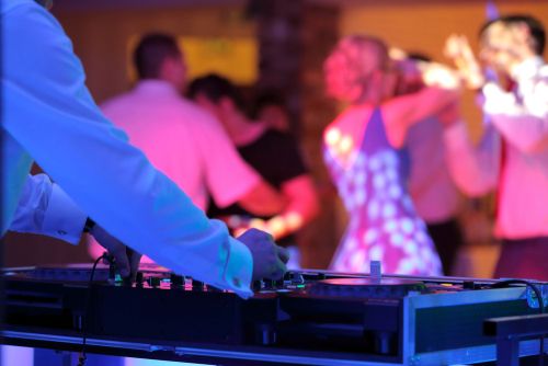 djs are dancing at a party with their hands in the air