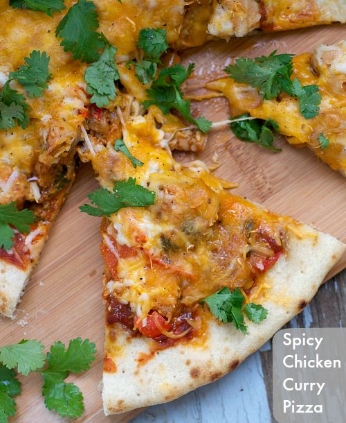 the pizza is cut into four pieces and has cilantro leaves on top of it