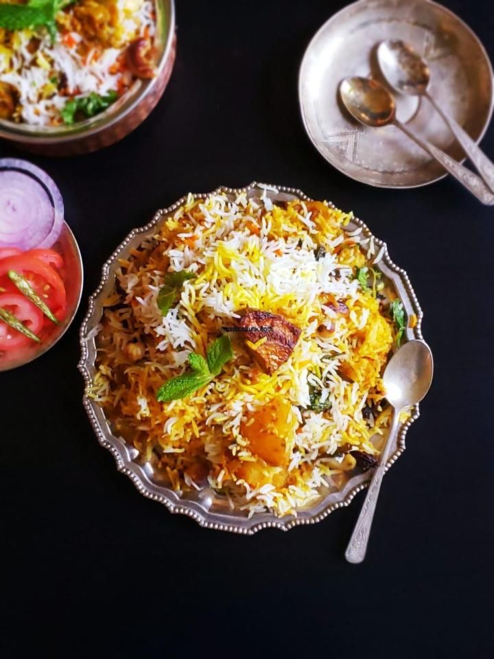 two bowls filled with different types of food on top of a black table next to silver spoons