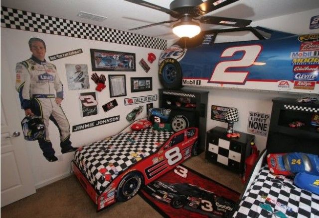 a bedroom with two beds and race cars on the wall