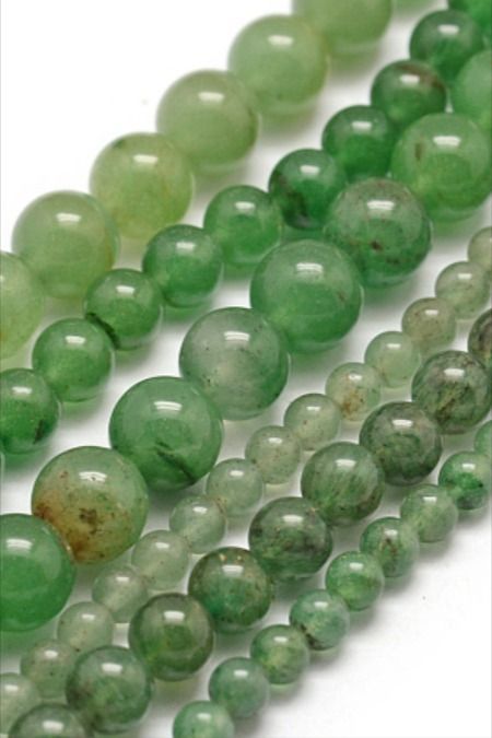 green jade beads are lined up on a white surface