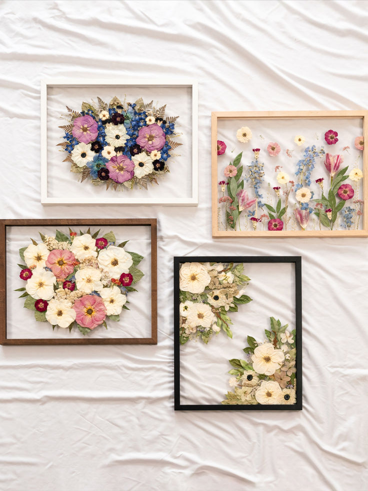 three framed pictures with flowers in them on a white sheet