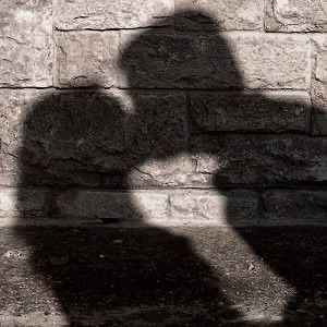 the shadow of a person's head on a brick wall