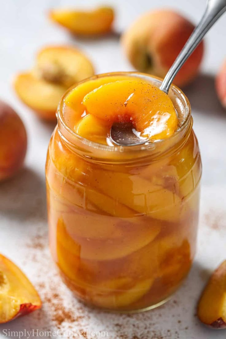 a jar filled with sliced peaches on top of a table