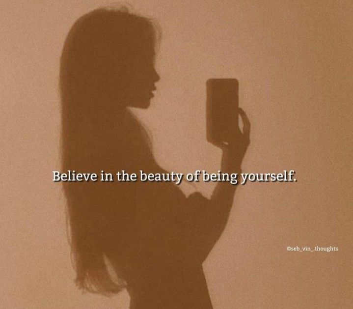 a woman holding a cell phone in her hand with the words believe in the beauty of being yourself