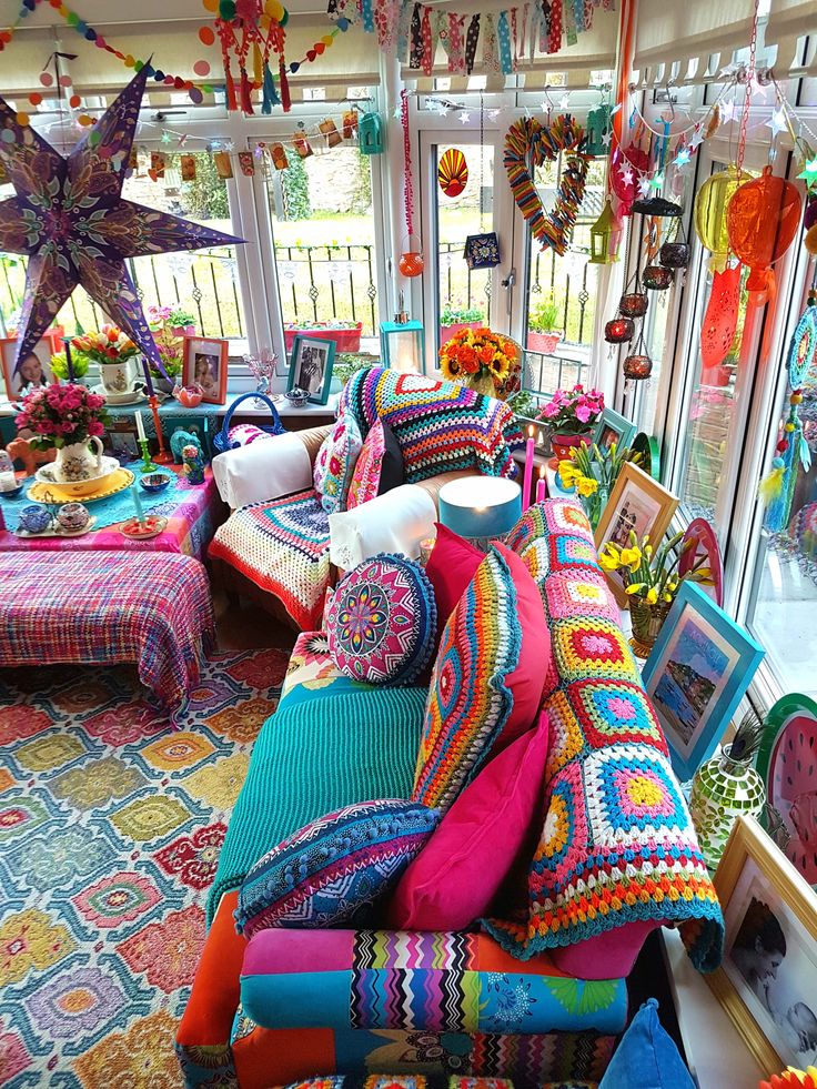 a room filled with lots of colorful pillows and blankets on top of eachother