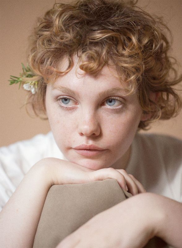 a close up of a person wearing a white shirt and holding a brown paper bag