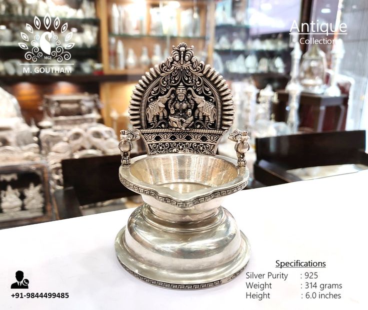 an ornate silver bowl sitting on top of a table in front of other glass cases