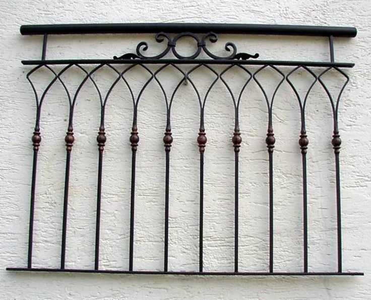 a wrought iron balcony railing on the side of a building