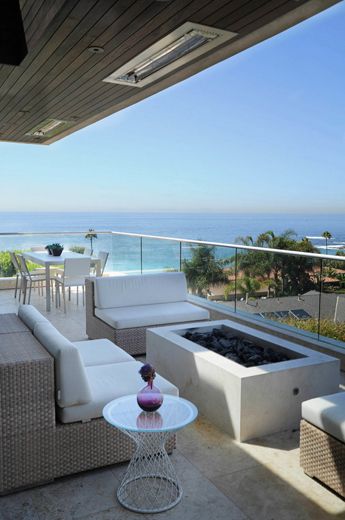 a living room with white furniture and an ocean view from the outside patio area,