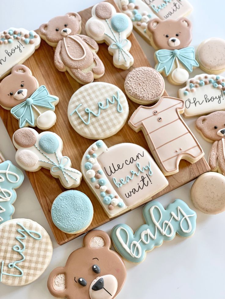 decorated cookies with teddy bears and baby names on wooden trays next to each other