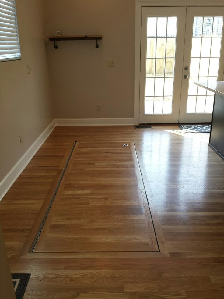 an empty living room with hard wood floors and sliding glass doors that lead to the front door