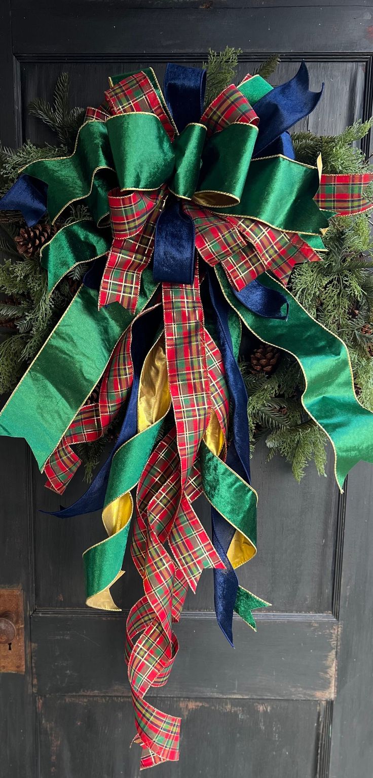 a green, red and blue christmas wreath hanging on a door