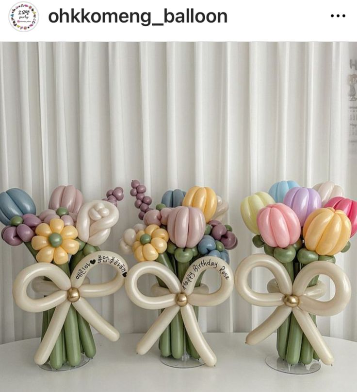 three vases filled with colorful flowers on top of a white table next to a curtain