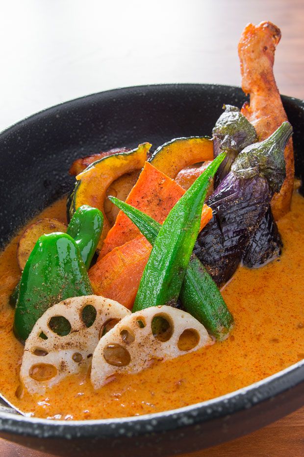 a black bowl filled with food on top of a wooden table