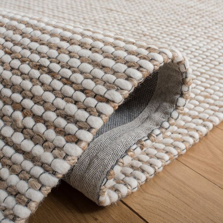 a close up view of a rug on the floor with wood floors in the background