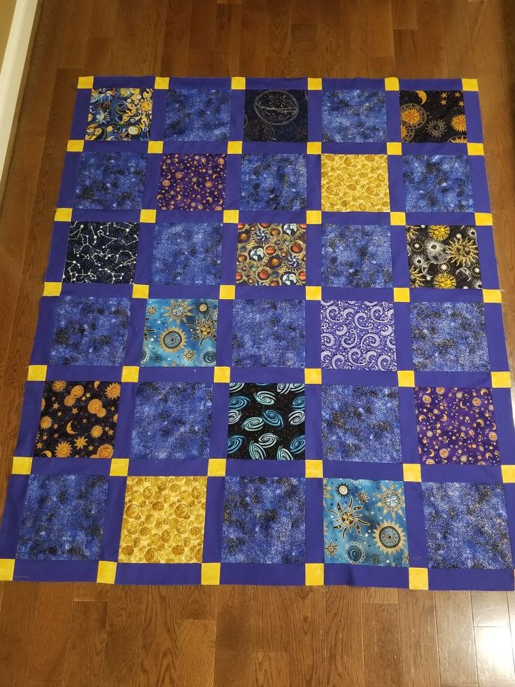 a blue and yellow patchwork quilt on the floor