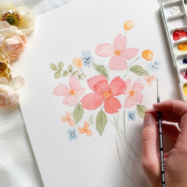 a person is painting flowers with watercolors