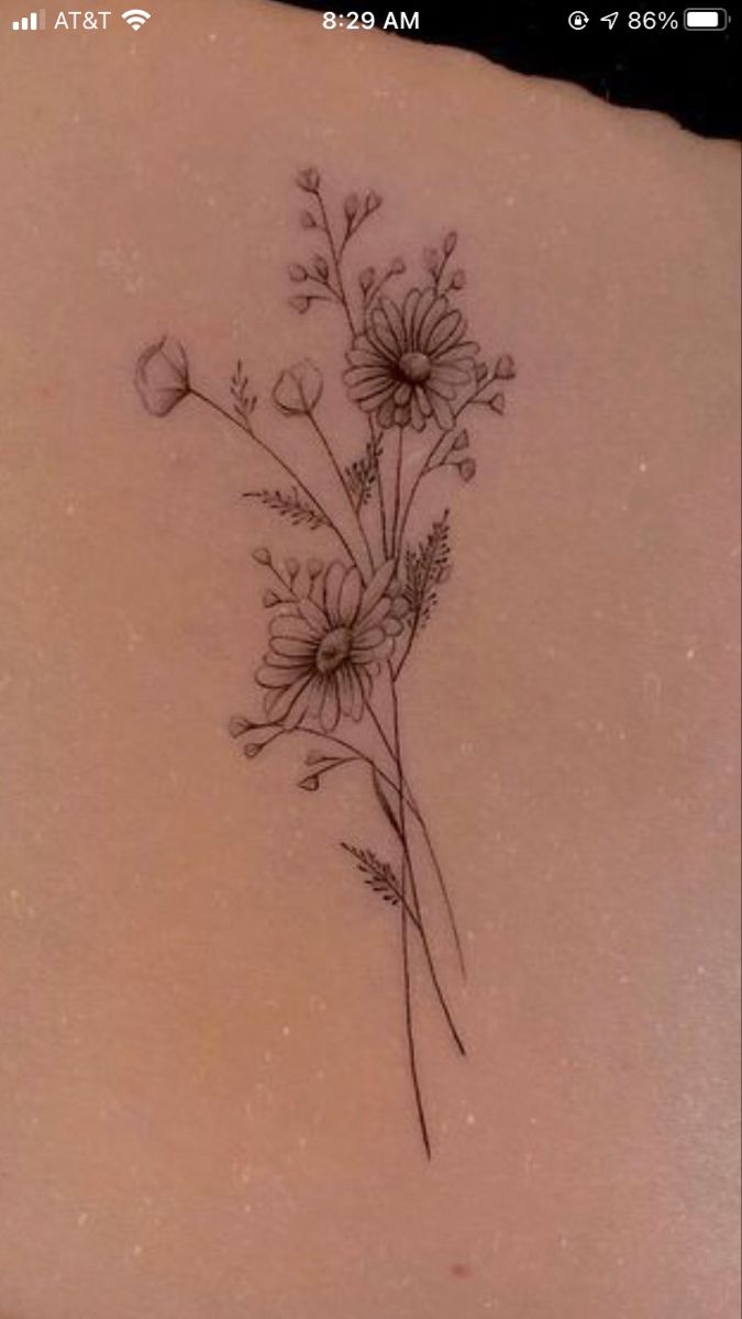 the back of a woman's stomach with flowers tattooed on her left side ribcage